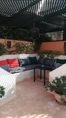 a patio with a bench with pillows on it at Riad Achwaq in Marrakech