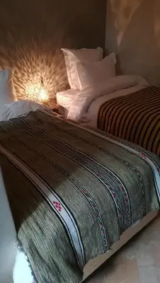 a bed with a blanket on it in a room at Riad Achwaq in Marrakech