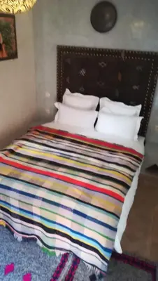 a bed with a colorful blanket on top of it at Riad Achwaq in Marrakech