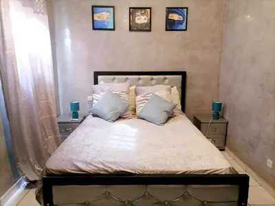 a bedroom with a large bed with two pillows at Riad Ansar in Marrakech