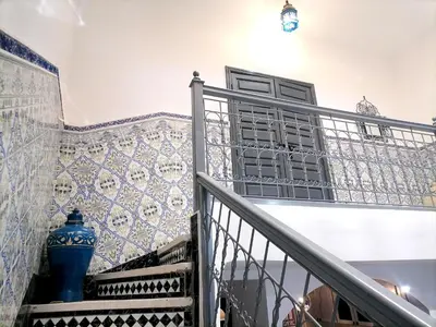 a staircase with a blue vase on the wall at Riad Ansar in Marrakech