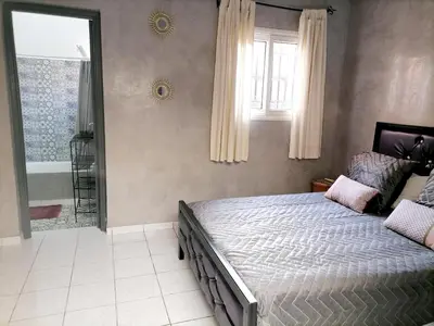 a bedroom with a large bed and a bath tub at Riad Ansar in Marrakech