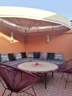 a room with a couch and a table and chairs at Riad Ansar in Marrakech
