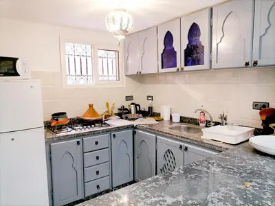 a kitchen with blue cabinets and a white refrigerator at Riad Ansar in Marrakech
