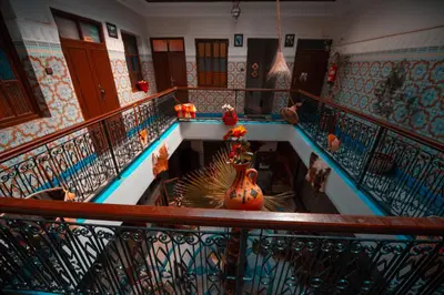 a hallway with a staircase with a vase on the floor at Riad dar Assou in Marrakech