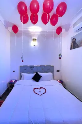 a bedroom with red balloons hanging above a bed at Riad dar Assou in Marrakech