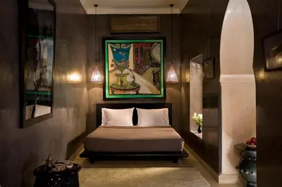 a bedroom with a bed with a painting on the wall at Riad Meriem in Marrakech