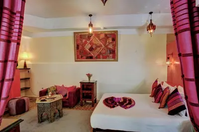a bedroom with a bed and a couch and a table at Riad Dar El Souk in Marrakech