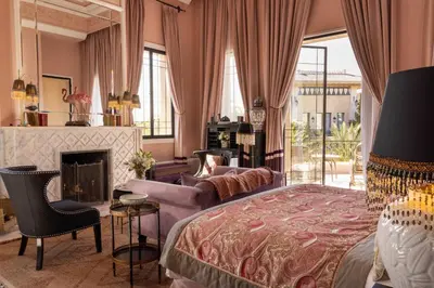 a bedroom with a king sized bed and a fireplace at Palais Ronsard Relais & Chateaux in Marrakech
