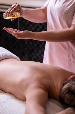 a shirtless man laying on a bed getting a massage at Palais Ronsard Relais & Chateaux in Marrakech