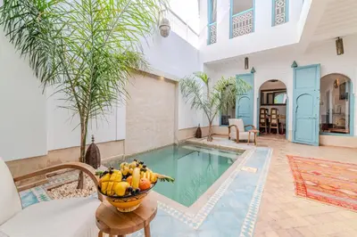 a villa with a pool and a table with a bowl of fruit at Riad Ayla avec Piscine Privée in Marrakech