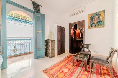 a living room with a chair and a table at Riad Ayla avec Piscine Privée in Marrakech