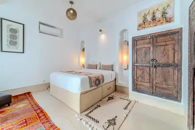 a bedroom with a bed and an open door at Riad Ayla avec Piscine Privée in Marrakech