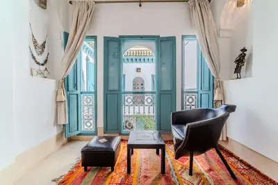 a living room with a chair and a table at Riad Ayla avec Piscine Privée in Marrakech