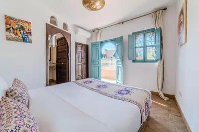 a bedroom with a bed and an open door at Riad Ayla avec Piscine Privée in Marrakech