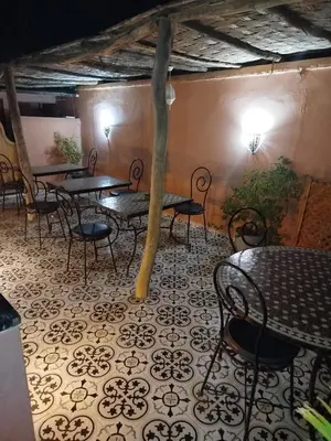 a room with tables and chairs and a tree at Riad Bab Lakhmiss in Marrakech