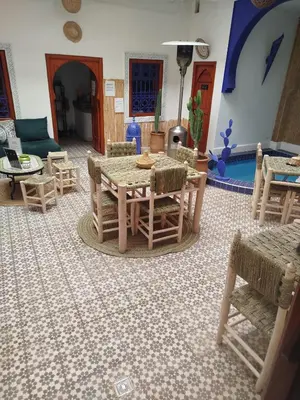 a living room with a table and chairs at Riad Bab Lakhmiss in Marrakech