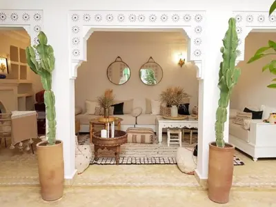 a living room with two cacti in pots at Riad Le Limoun and Spa in Marrakech