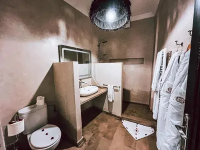 a bathroom with a toilet and a sink and a mirror at Riad Al Rimal & Spa in Marrakech