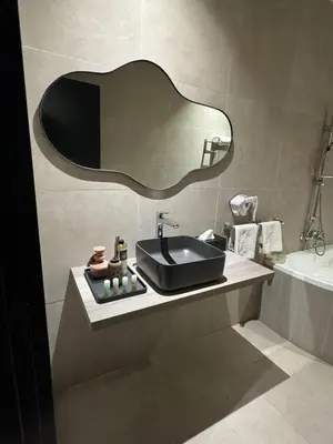a bathroom with a sink and a mirror on the wall at Rawabi Hotel Marrakech & Spa in Marrakech