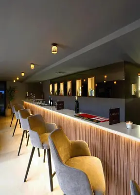 a bar with a row of chairs in a restaurant at Rawabi Hotel Marrakech & Spa in Marrakech