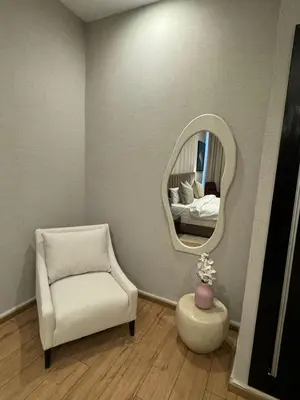 a living room with a chair and a mirror at Rawabi Hotel Marrakech & Spa in Marrakech