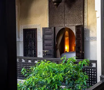a building with a chair and a plant in front at Dar Les Cigognes in Marrakech