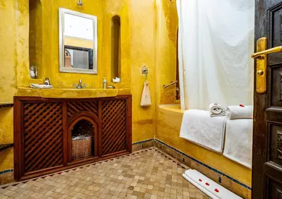 a bathroom with a tub and a sink and a shower at Dar Les Cigognes in Marrakech