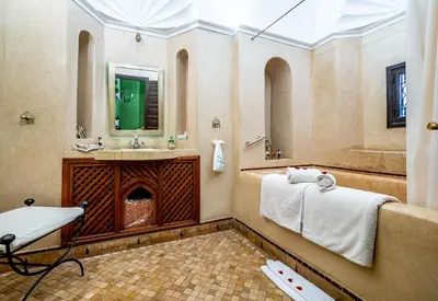 a bathroom with a sink and a shower with a fireplace at Dar Les Cigognes in Marrakech