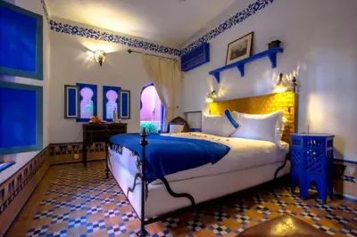 a bedroom with a large bed with blue and white at Riad Kaiss By Anika in Marrakech