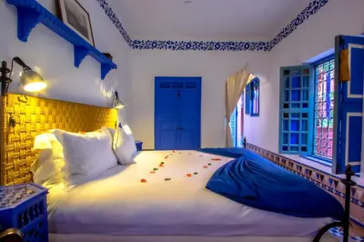 a bedroom with a large white bed with flowers on it at Riad Kaiss By Anika in Marrakech
