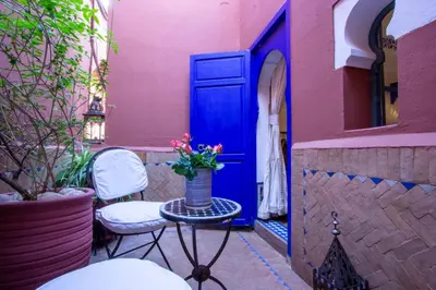 a vase with flowers on a table in front of a door at Riad Kaiss By Anika in Marrakech