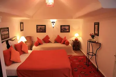 a bedroom with two beds with red pillows at Riad Eden in Marrakech