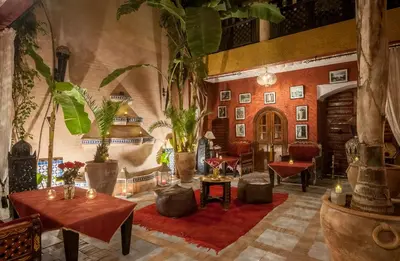 a lobby with tables and plants in a building at Riad Eden in Marrakech