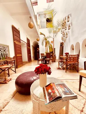 a living room with a table with flowers on it at Riad la Cigale in Marrakech