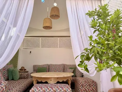 a living room with a table and a couch at Riad la Cigale in Marrakech