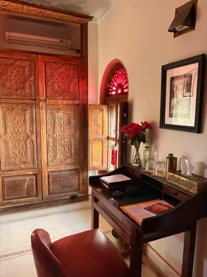 a room with a desk with a vase of flowers at Riad la Cigale in Marrakech