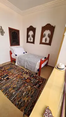 a bedroom with a bed and a rug on the floor at Riad la Cigale in Marrakech
