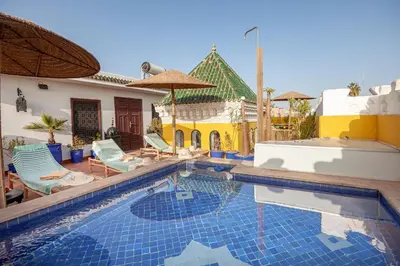 a swimming pool with chairs and a house at Riad Kech Soul Boutique & Spa in Marrakech
