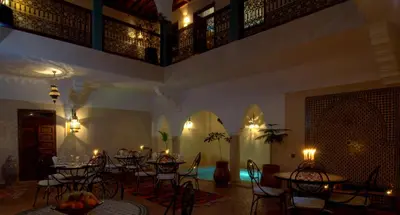 a room with tables and chairs in a room with lights at Riad Imilchil in Marrakech