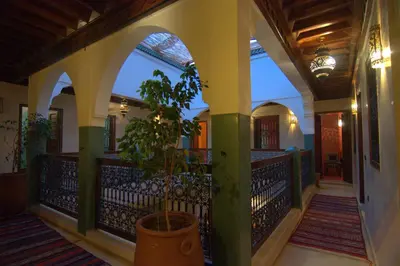 a house with a potted plant on a balcony at Riad Imilchil in Marrakech
