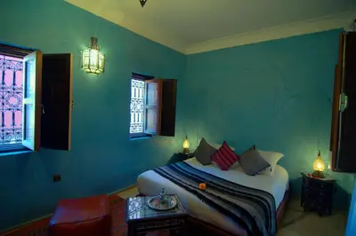 a bedroom with a bed in a room with green walls at Riad Imilchil in Marrakech