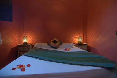 a bedroom with a bed with two lights on it at Riad Imilchil in Marrakech