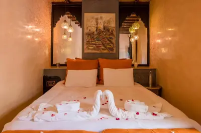 a bed with white sheets and towels on it at Riad L'Evidence in Marrakech