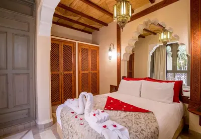 a bedroom with a bed with towel animals on it at Riad L'Evidence in Marrakech