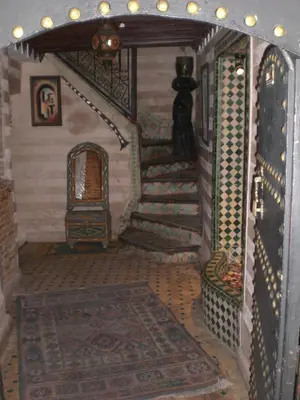 a hallway with a staircase and a room with a fireplace at Riad Hiba in Marrakech