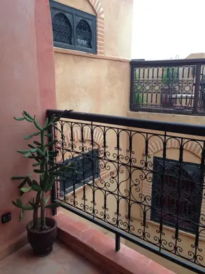 a balcony with a black railing and a potted plant at Riad Hiba in Marrakech