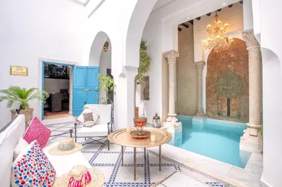 a living room with a table and blue water at Riad Khalifa in Marrakech
