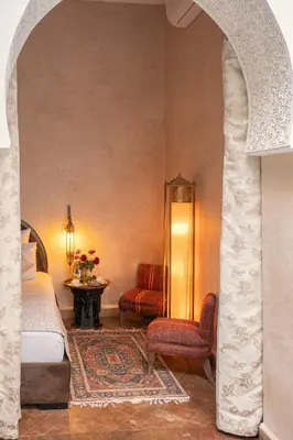 a bedroom with a bed and a chair and a table at Riad Khalifa in Marrakech