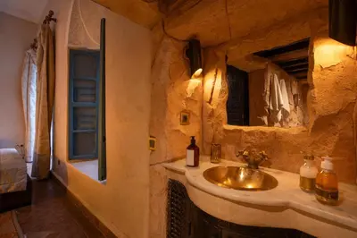 a stone bathroom with a sink and a mirror at Riad Khalifa in Marrakech